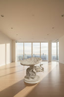 A white carved elephant-shaped pedestal table .