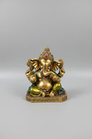 A gold-toned Ganesha statue with colorful painted accents.
