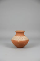 A terracotta clay pot with a wide flared rim and embossed floral patterns on the body.