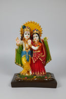 A colorful religious figurine of Lord Krishna and Radha standing 