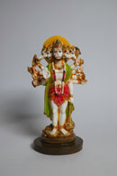 A multicolored statue of Lord Hanuman standing .