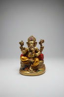 Lord Ganesha statue seated on a decorated base.