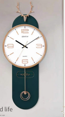 A wall clock with a dark teal-green elongated body, a white dial, rose-gold.