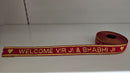 Red ribbon with gold text 'WELCOME VIRJI & BHABHIJI' on a white background